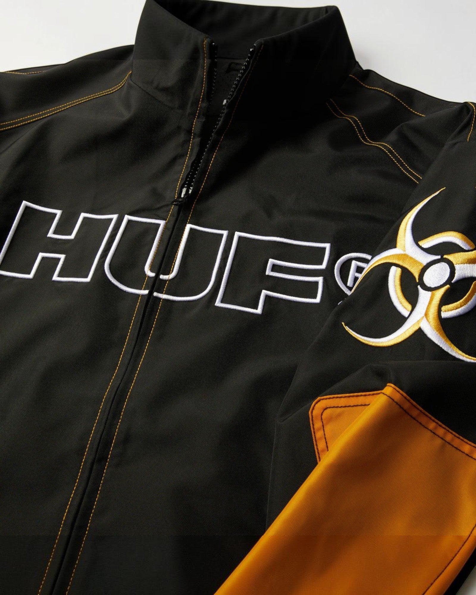 impostor.ro HUF Sector Jacket in black with white HUF logo and yellow biohazard symbol on sleeve.